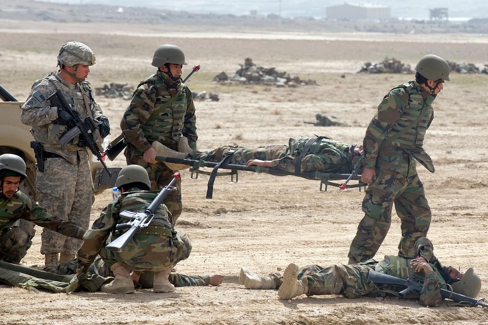 Afghan National Army soldiers respond to a simulated improvised explosive device attack while a U.S. Army trainer looks on…