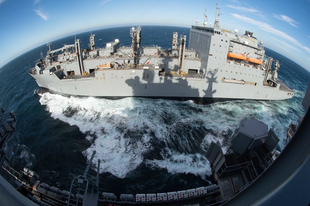 The dry cargo and ammunition ship USNS Charles Drew (T-AKE 10) steams alongside the aircraft carrier USS John C. Stennis…