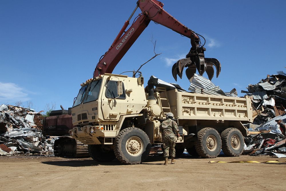 A U.S. Soldier with the Guam Army National Guard releases tie straps from a military tactical vehicle for commercial heavy…