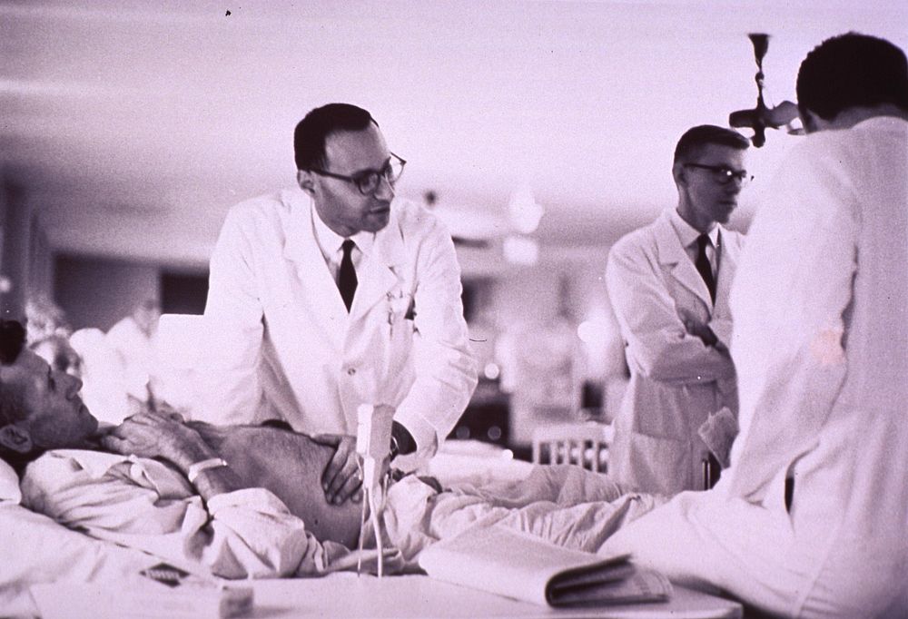 Physician examining a patient at bedside. Original public domain image from Flickr