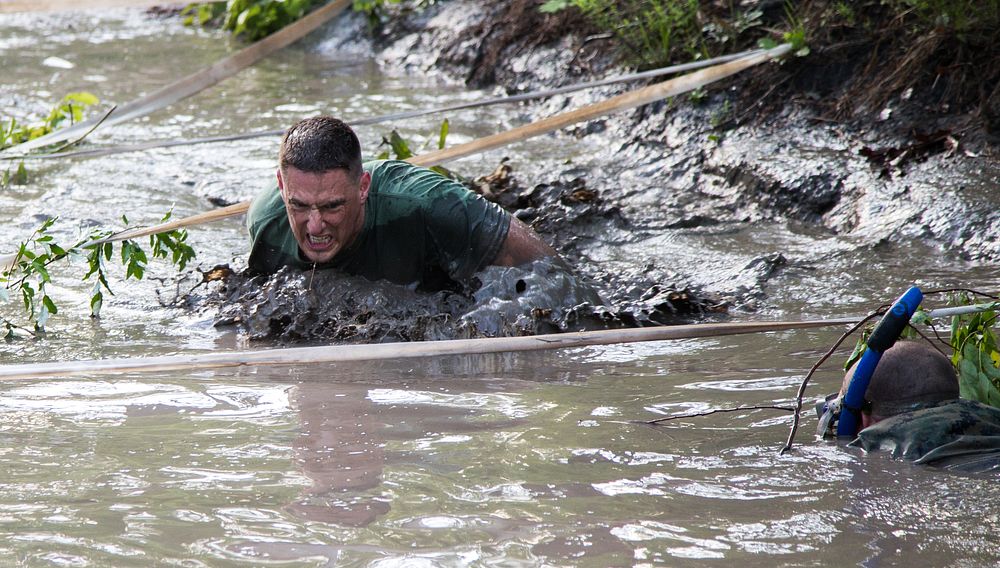 U.S. Marine Lt. Col. Gregory E. DeMarco mud crawls during the Marine Wing Headquarters Squadron (MWHS) 2 Spartan Race at…