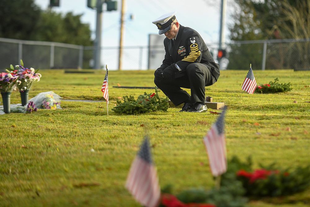 U.S. Navy Command Master Chief James Willis, the command master chief of Naval Base Kitsap, lays a wreath at the grave of a…