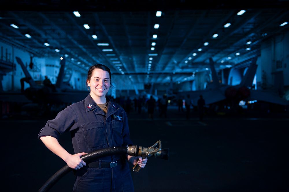 U.S. Navy Damage Controlman 2nd Class Jeanette Rochefort, from Massena, N.Y., poses for a photo in the hangar bay aboard the…