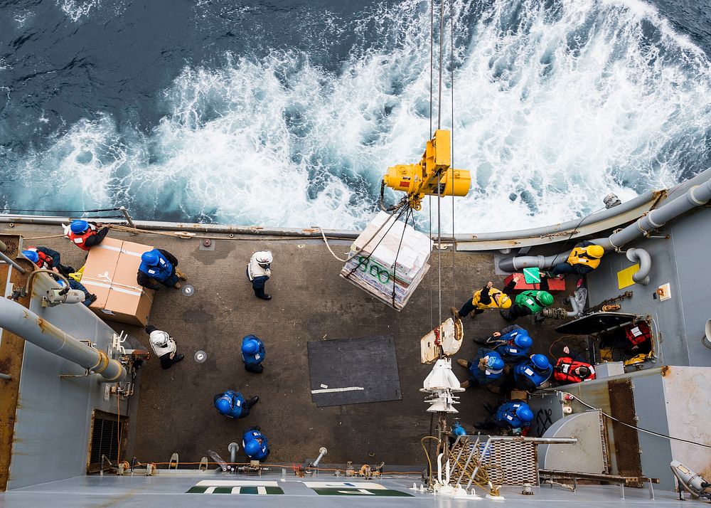 U.S. Sailors aboard the amphibious dock landing ship USS Ashland (LSD 48) receive supplies during a replenishment-at-sea…