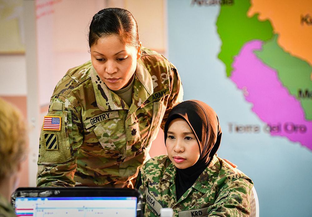 U.S. Army Lt. Col. Angela Gentry, Washington Army National Guard, discusses battle drills with her Malaysian army…