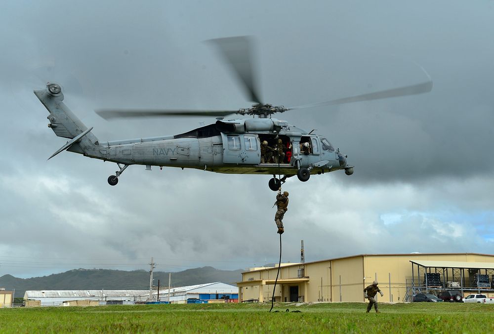 A U.S. Navy Sailor assigned to Explosive Ordnance Disposal Mobile Unit 5 (EODMU 5) fast-ropes from an MH-60S Seahawk…