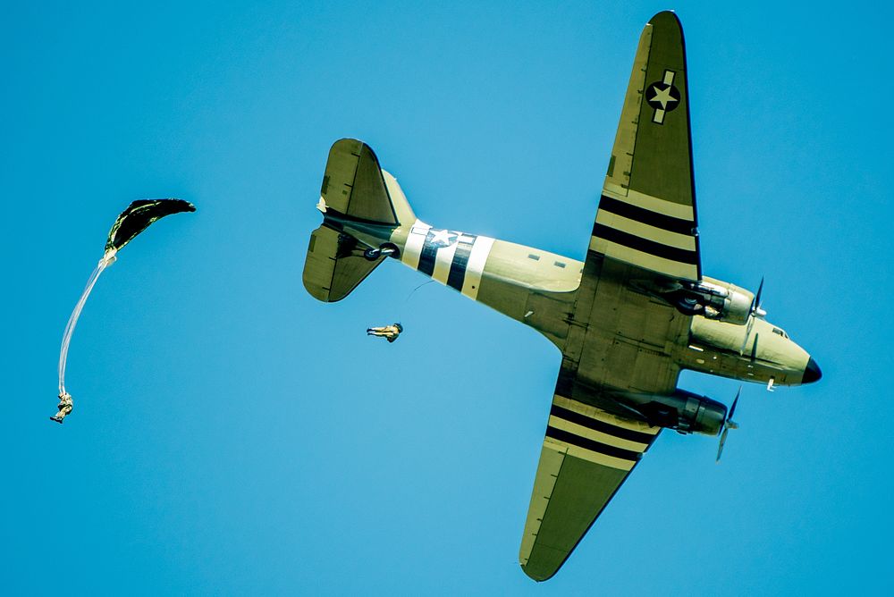 Two members of the Liberty Jump Team, a commemorative team of volunteer parachutists, jump out of a restored C-47 Skytrain…