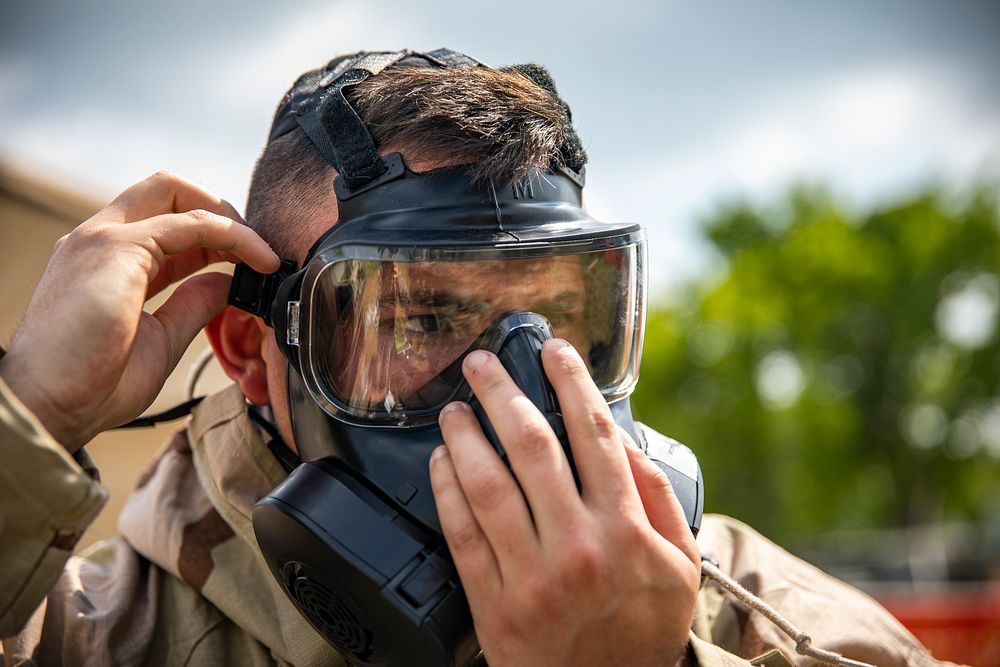 A U.S. Marine with Marine Aircraft Group 41, 4th Marine Aircraft Wing, puts on a M-50 joint service general purpose mask…