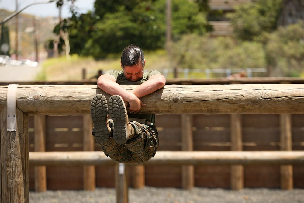 Midshipman Stephanie Metzger, a Cumming, Georgia, native, struggles to get over a log amid the School of Infantry (SOI)…