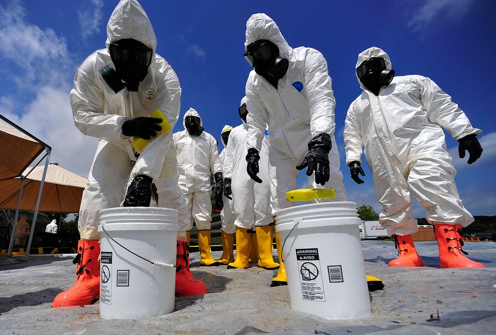 U.S. Soldiers from the 457th Chemical Battalion sponge off their level A protective suits after a simulated nuclear…