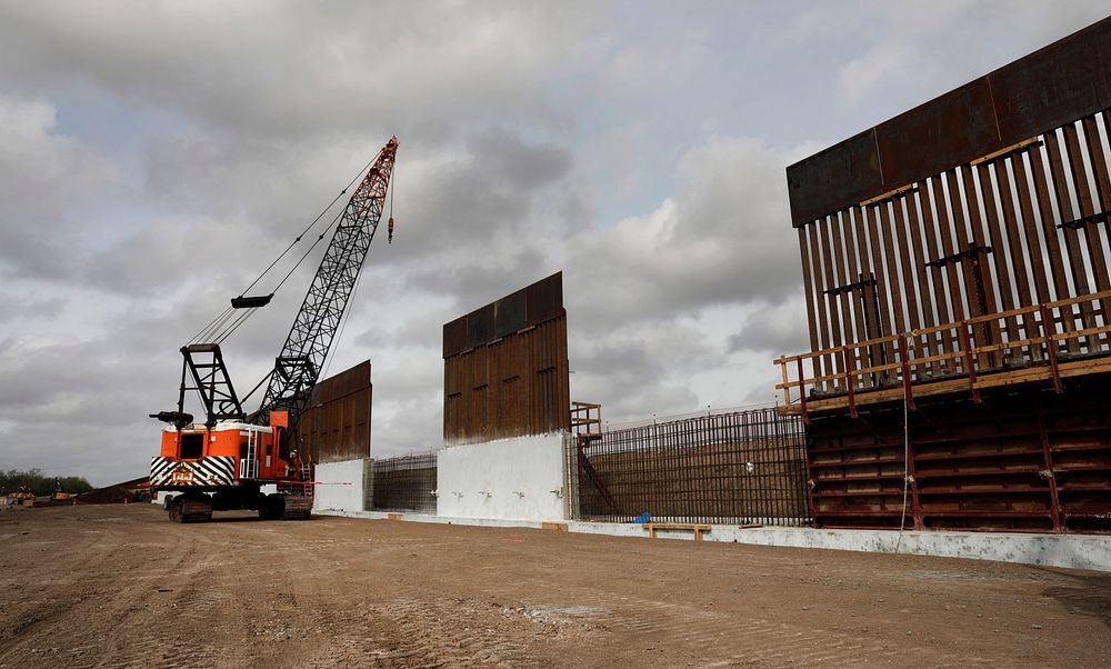 Construction crews work to erect levee wall system in a remote area south of Weslaco, Texas in the U.S. Border Patrol’s Rio…