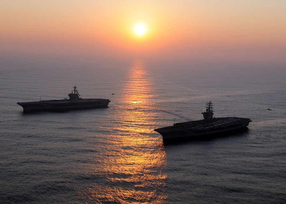 The aircraft carriers USS George H.W. Bush (CVN 77), left, and USS Dwight D. Eisenhower (CVN 69) conduct a vertical…