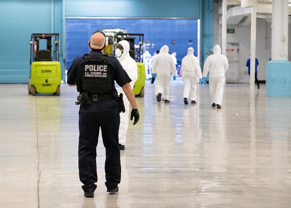 U.S. Customs and Border Protection officers wear personal protective equipment to guard against coronavirus as they…