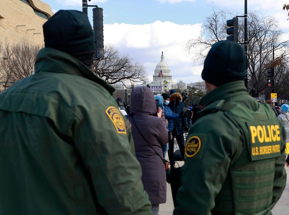The U.S. Capitol can be seen framed between two U.S. Border Patrol agents as they stand their post supporting the…