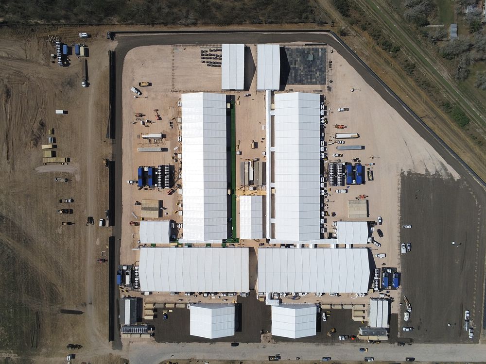 Temporary processing facilities are constructed in Donna, Texas, February 2, 2021, to safely process family units and…