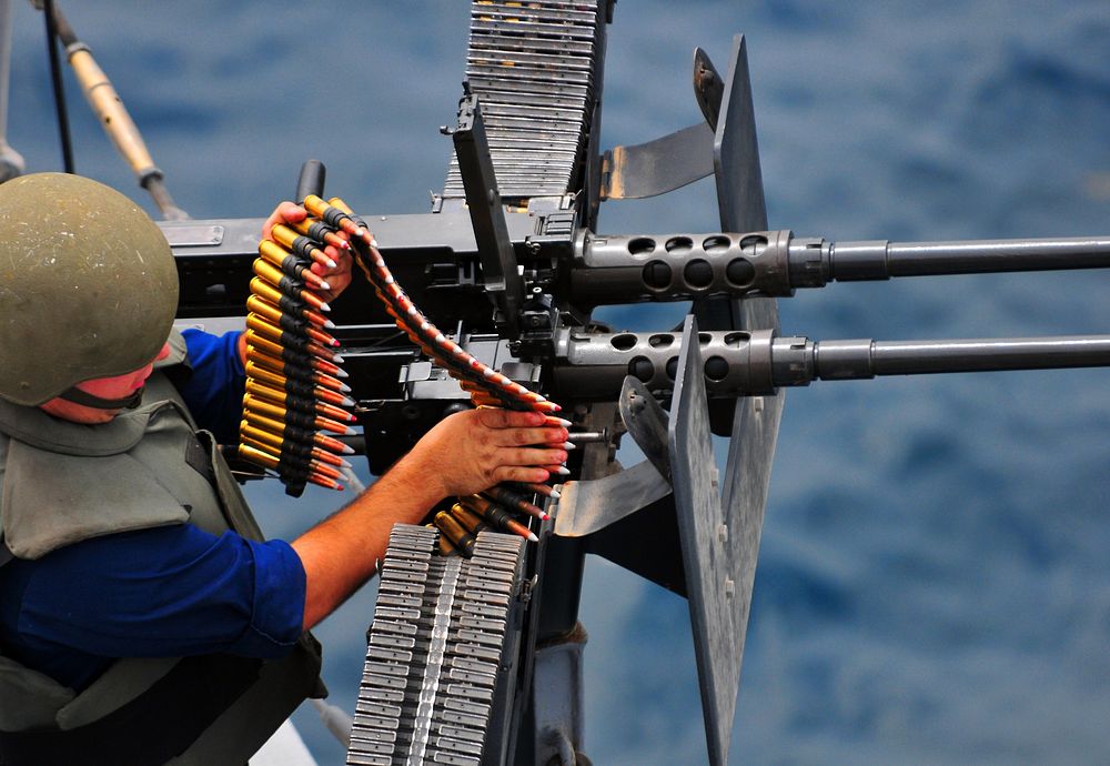 U.S. Navy Gunner's Mate 3rd Class Matthew Montalbano loads a .50-caliber machine gun during a small-craft action team (SCAT)…
