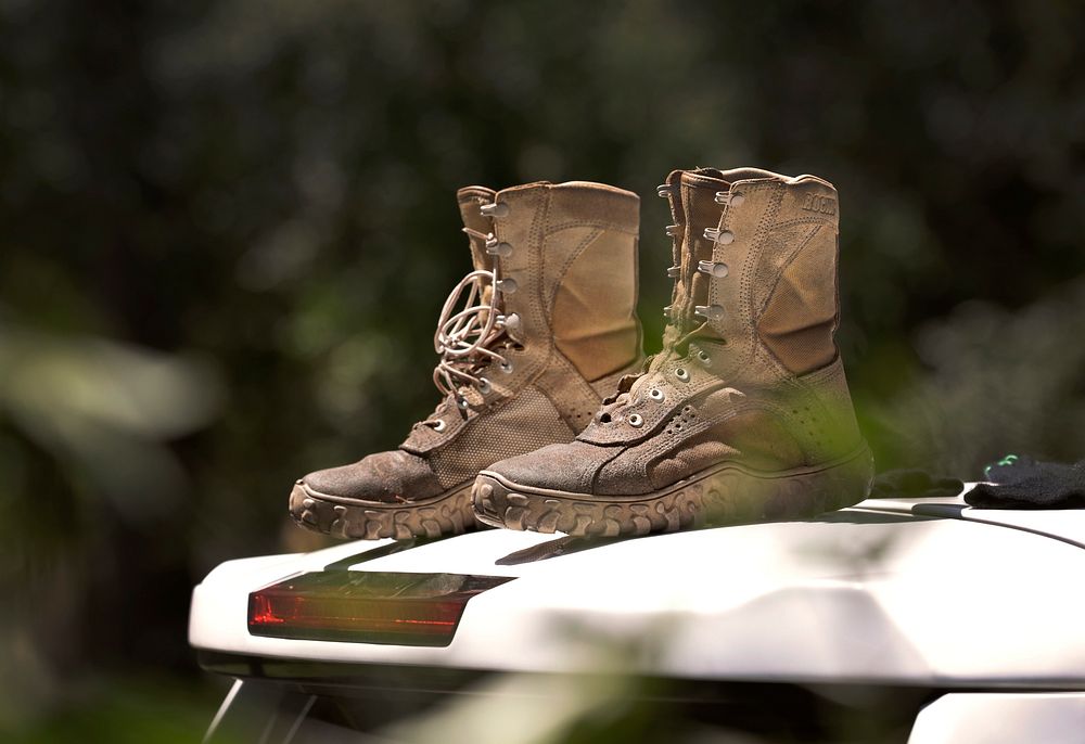 A U.S. Border Patrol agent’s wet boots sit atop a Border Patrol vehicle to dry while he and fellow agents work to clear…