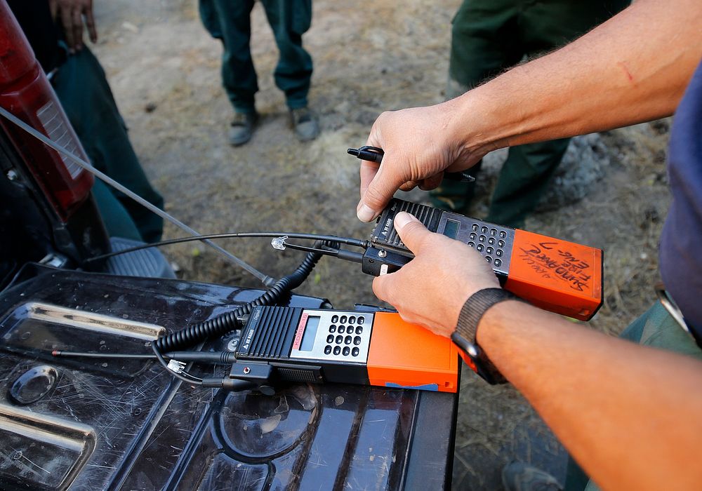 JUL 17 BLM Fire. CHILOQUIN, OR - JULY 17: Wildland firefighters clone radios before a night shift briefing on the Bootleg…