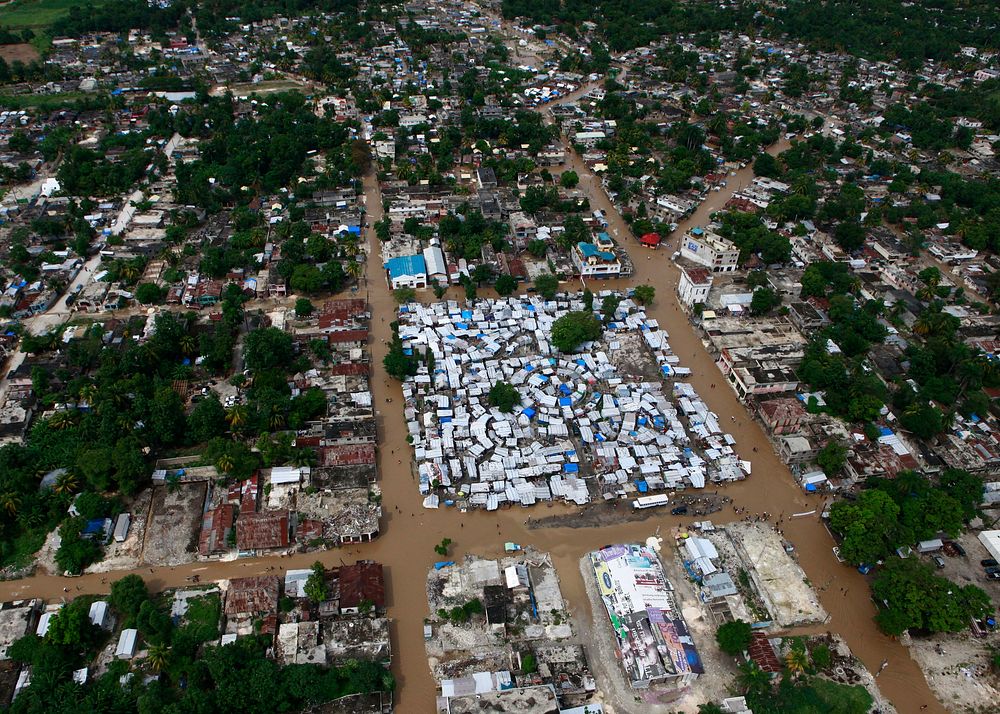 Floodwaters surround a tent city outside Port-au-Prince, Haiti, during a flyover by a U.S. Marine Corps helicopter Nov. 6…
