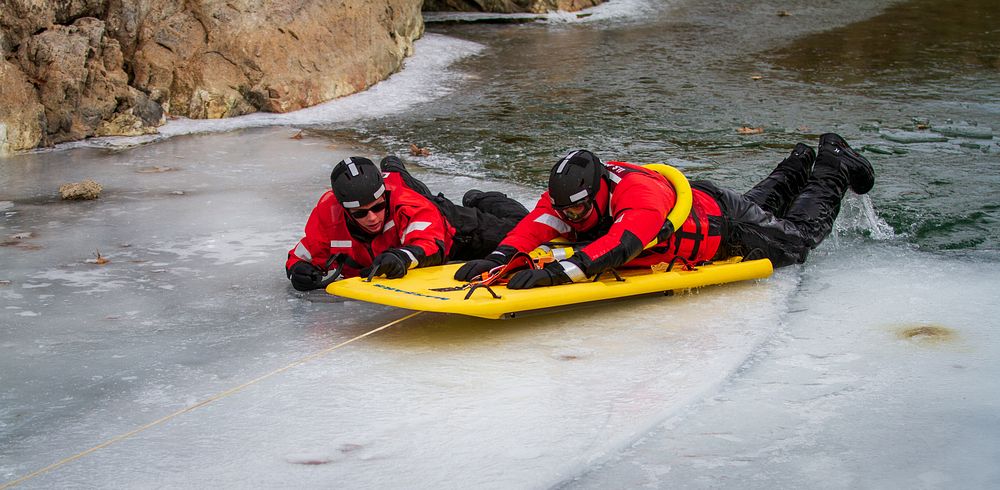 Members of the Coast Guard conduct ice rescue training by reeling in a simulated survivor in the water on a MARSARS Ice…