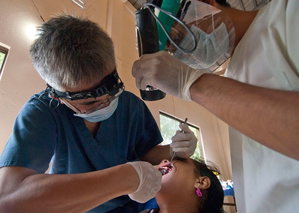U.S. Navy dentist Lt. Cdr. Vincent Do, left, and Royal Cambodian Army dentist 2nd Lt. Kea Sokheang, right, extract a…