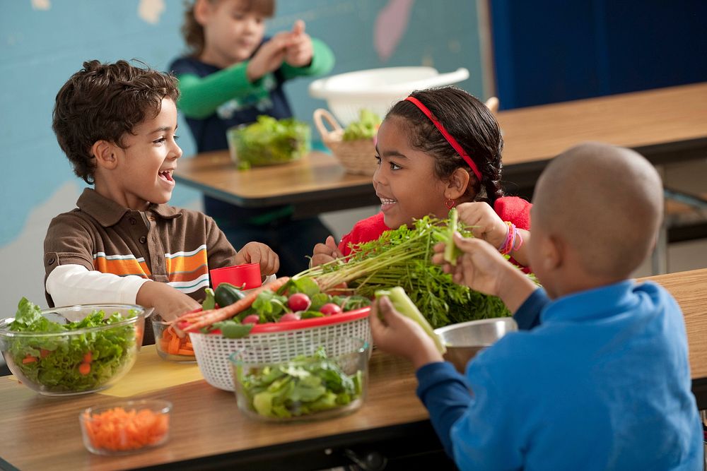 Elementary school students making a salad in the classroom. Original public domain image from Flickr