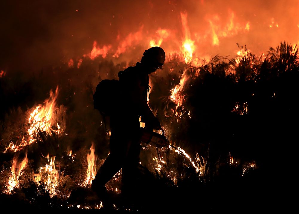 A firefighter conducts firing operations at night on the 2022 Sagehen Fire near Blackfoot, Idaho.