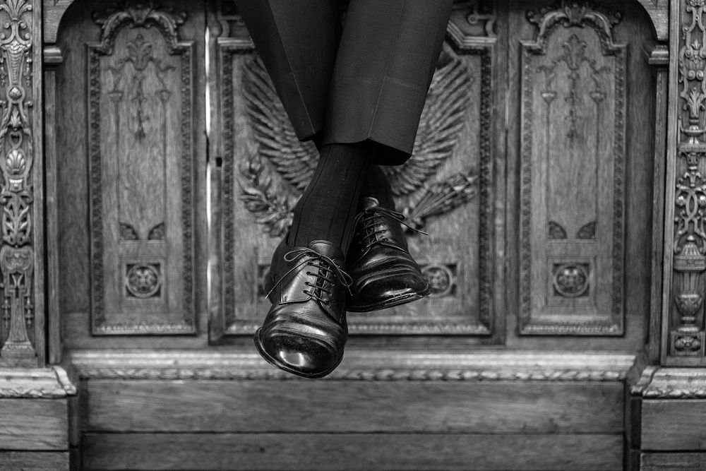 President Joe Biden sits on the Resolute Desk during a staff meeting, Friday, January 6, 2023, in the Oval Office. (Official…