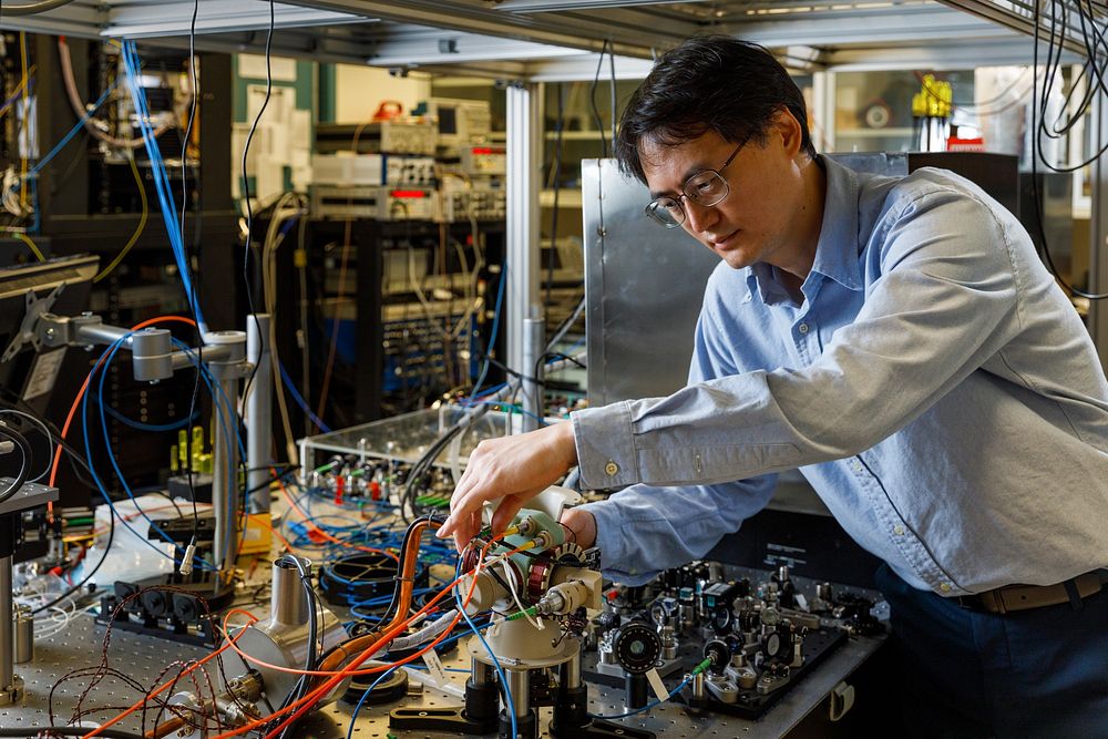 Sandia atomic physicist Jongmin Lee examines the sensor head of a cold-atom interferometer that could help vehicles stay on…