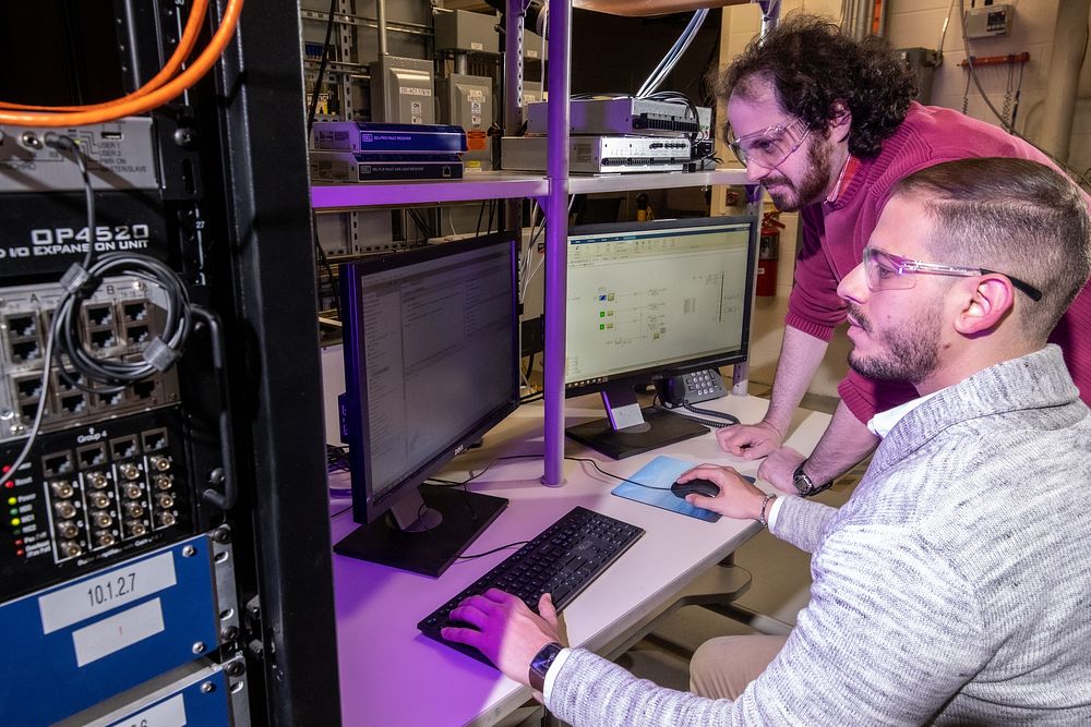Sandia National Laboratories electrical engineers Rachid Darbali-Zamora, front, and Lee Raskin test out an algorithm on a…