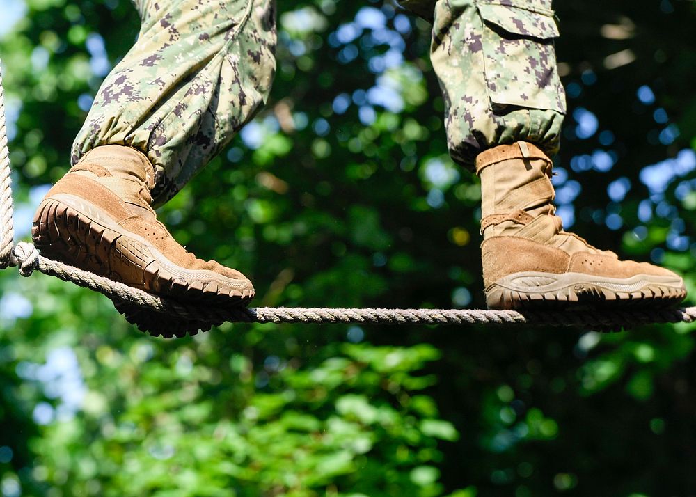 Soldier training walking on rope.