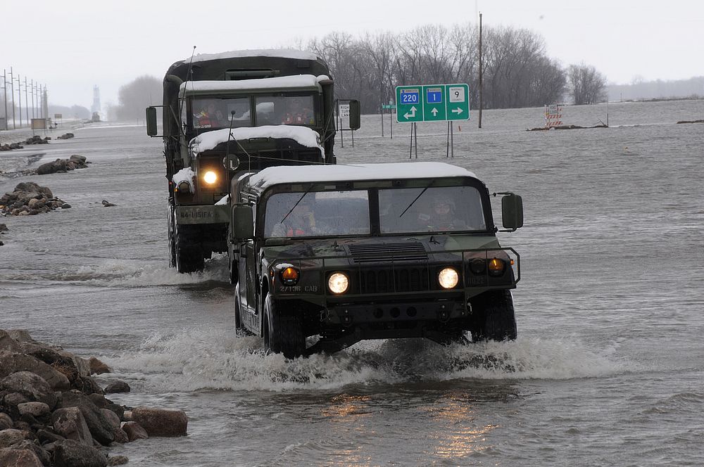 Minnesota Army National Guardsmen assigned to the 2nd Combined Arms Battalion, 136th Infantry drive through flood water…