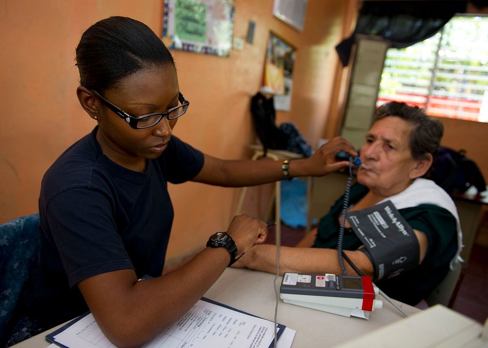 U.S. Navy Hospital Corpsman Seckisiesha Isaac, left, checks a Salvadoran woman's vitals at a prescreening vital signs…