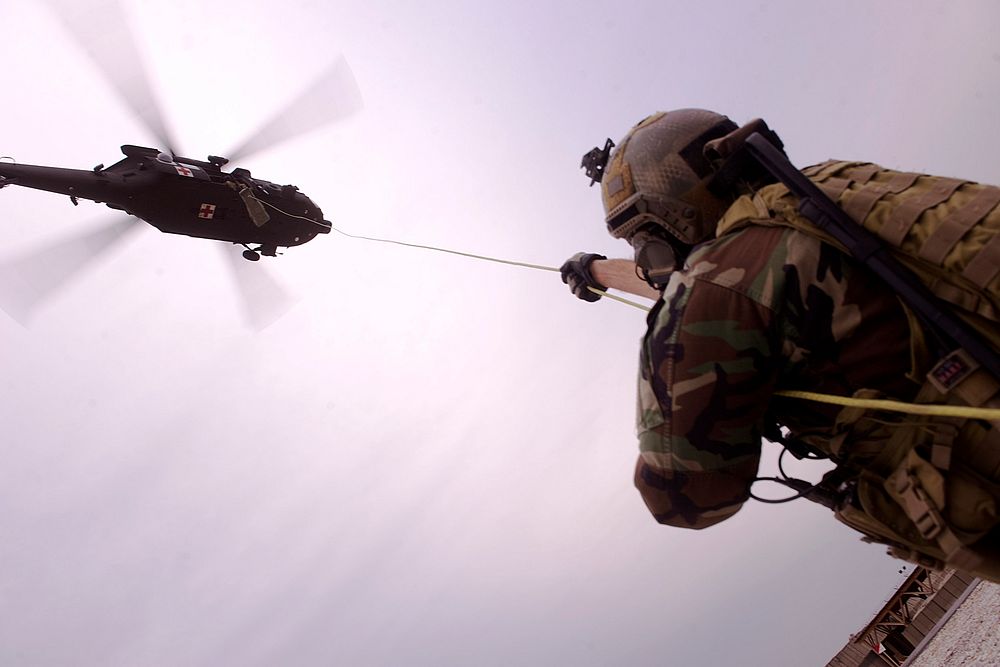 An Afghan National Army (ANA) commando helps hoist a litter into a UH-60 Black Hawk helicopter March 3, 2012, during medical…