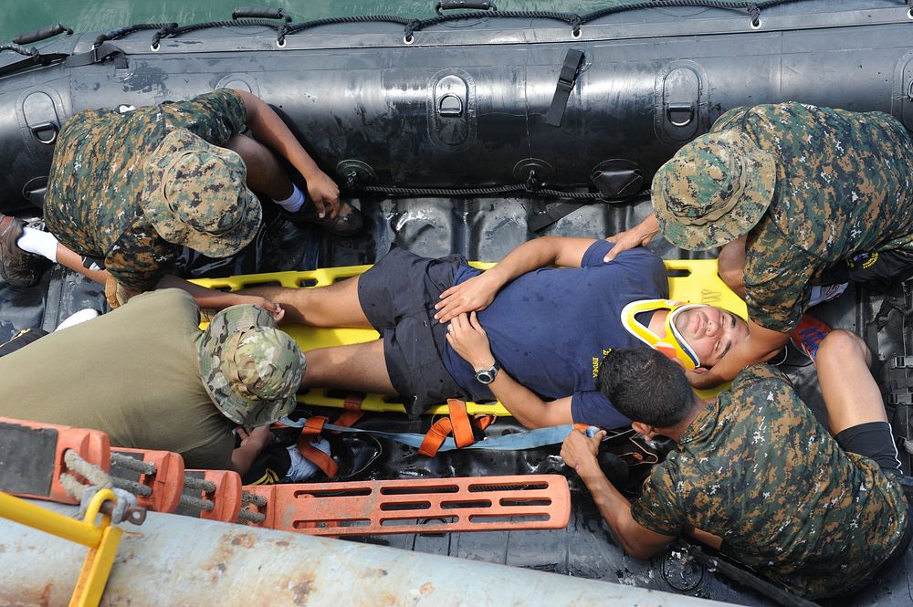 U.S. Navy Diver 2nd Class Matthew Kelly, assigned to Mobile Diving and Salvage Unit 2, Company 2-1, is placed on a stretcher…