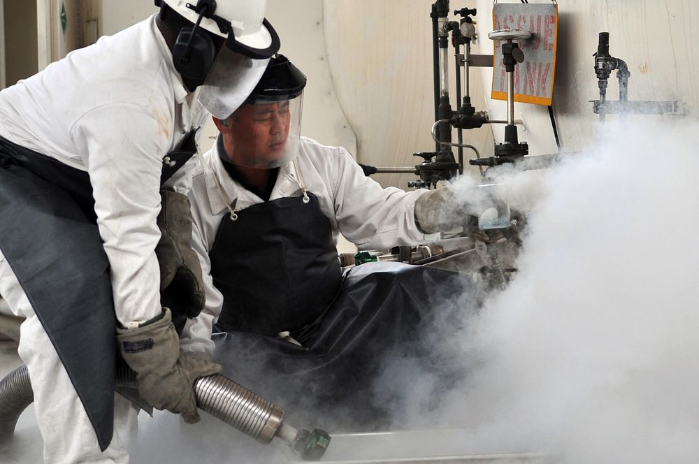 Staff Sgt. James Gardner and Mr. Ki-Hyon Pak push liquid oxygen into a beaker to perform an odor test here, April 9, 2012.