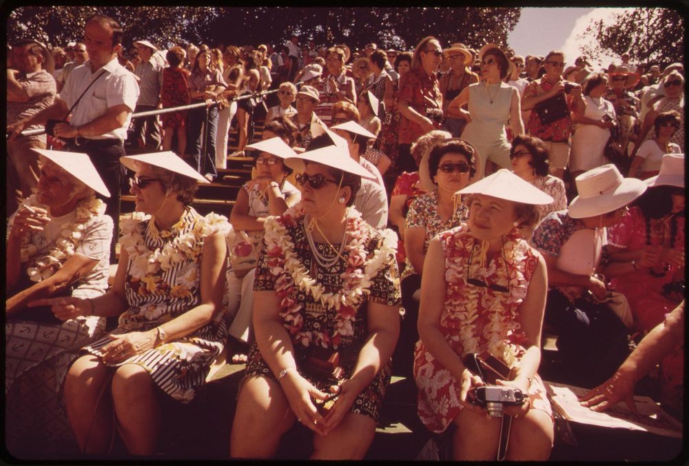 Tourists at a hula dance demonstration. Those who do the dance are rewarded with leis, October 1973. Photographer: O'Rear…