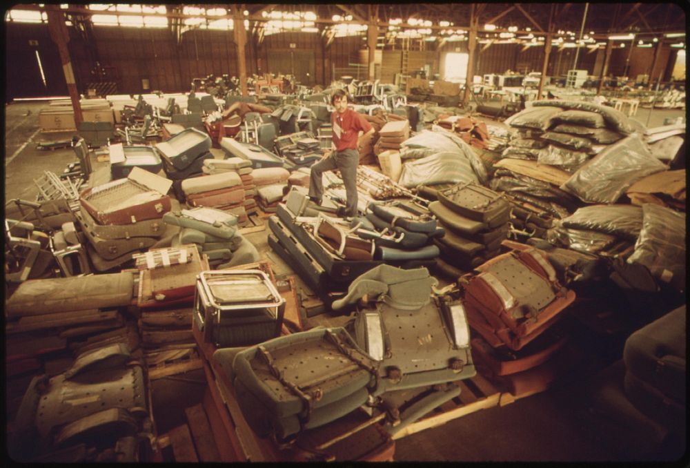 Old equipment from Amtrak passenger cars is piled in a warehouse, May 1974. Photographer: O'Rear, Charles. Original public…