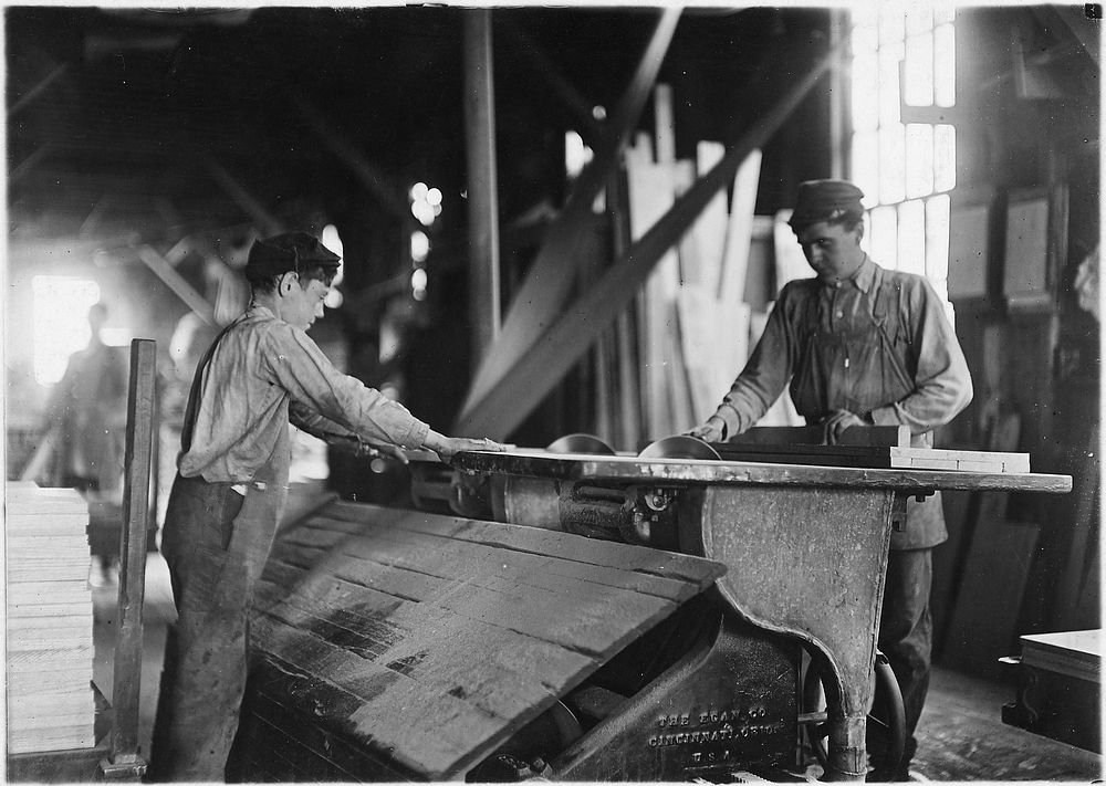 Boy working at double circular saws. N.Y. Dimension Supply Co., October 1908. Photographer: Hine, Lewis. Original public…