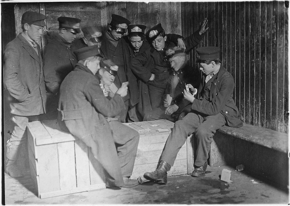 Flashlight photo of messengers absorbed in their usual game of poker in the Den of the terrible nine, March 1909.…