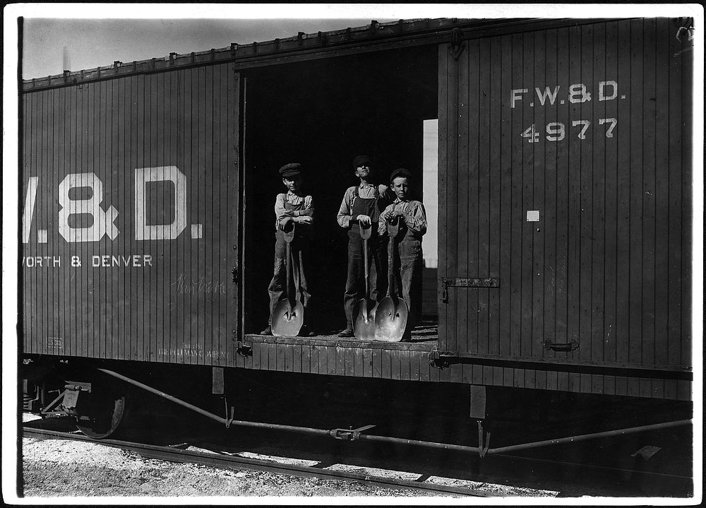 Three young boys with shovels standing in doorway of a Fort Worth & Denver train car, 1912. Photographer: Hine, Lewis.…