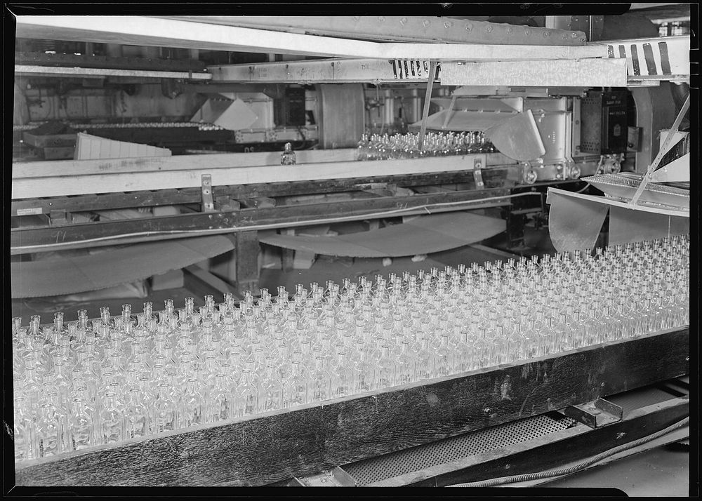 Numerous bottles in foreground and bottles on a conveyor belt, 1936. Photographer: Hine, Lewis. Original public domain image…