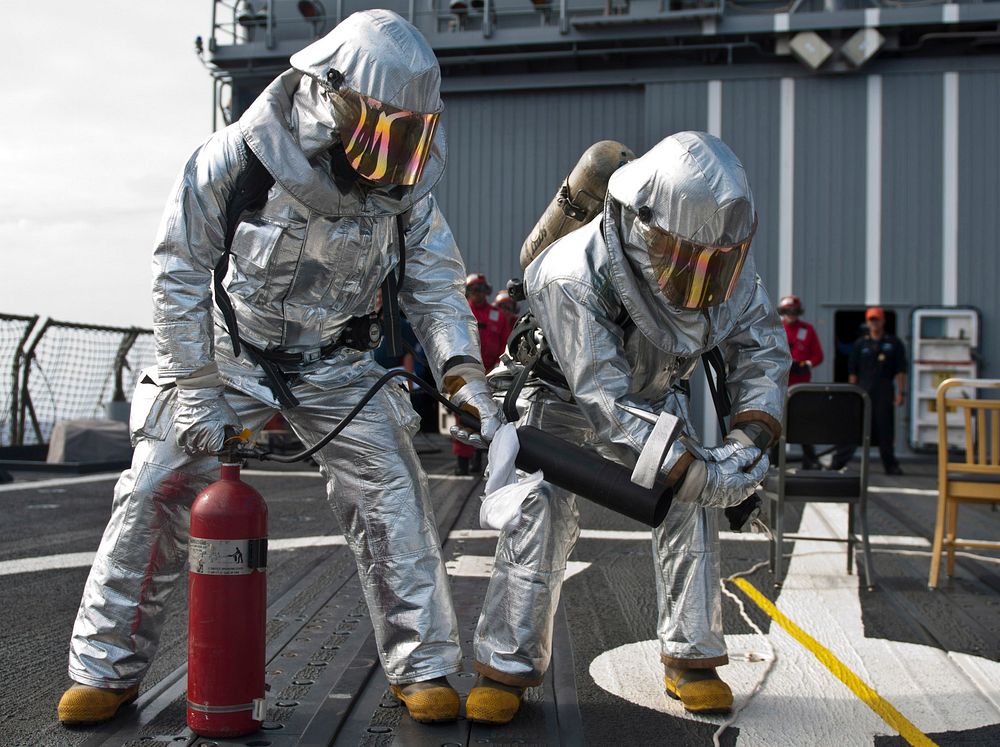 U.S. Navy Damage Controlman Firemen Daniel Kelly and Chris Kirkman confirm a simulated fire is extinguished during a…