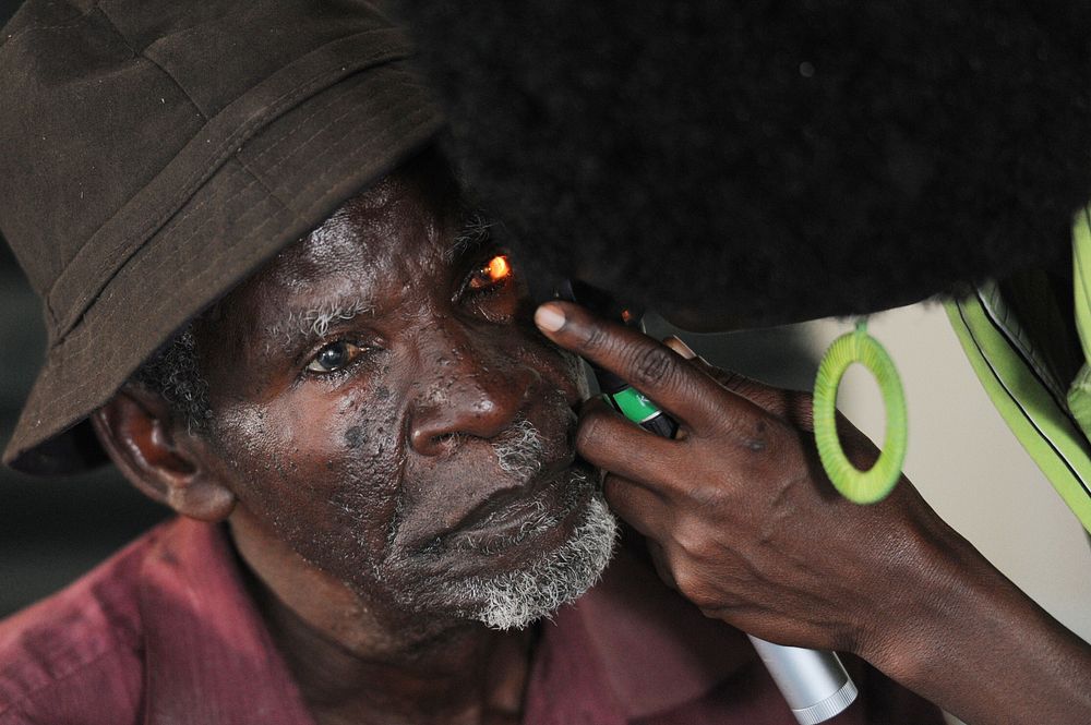 A community health worker examines a patient’s eye during a medical civic action program (MEDCAP) in Lunga Lunga, Kenya…