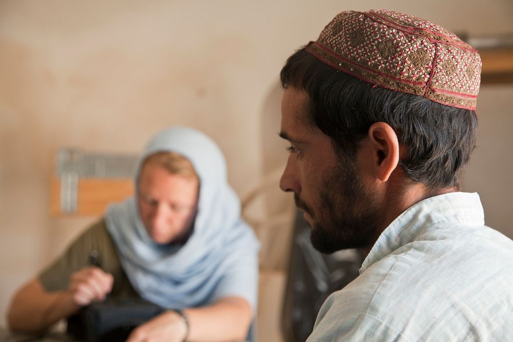 A coalition forces member assists an Afghan Local Policeman (ALP) with recordkeeping to ensure the ALP are legitimately…
