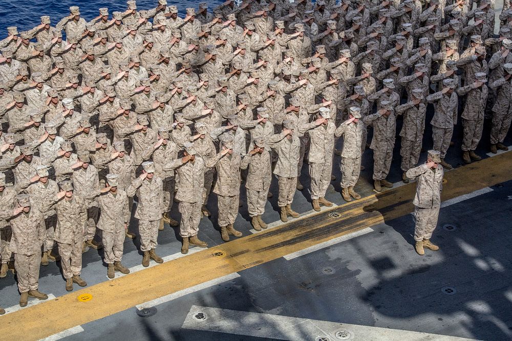 U.S. Marines and Sailors assigned to the 26th Marine Expeditionary Unit (MEU) render honors during a ceremony to celebrate…