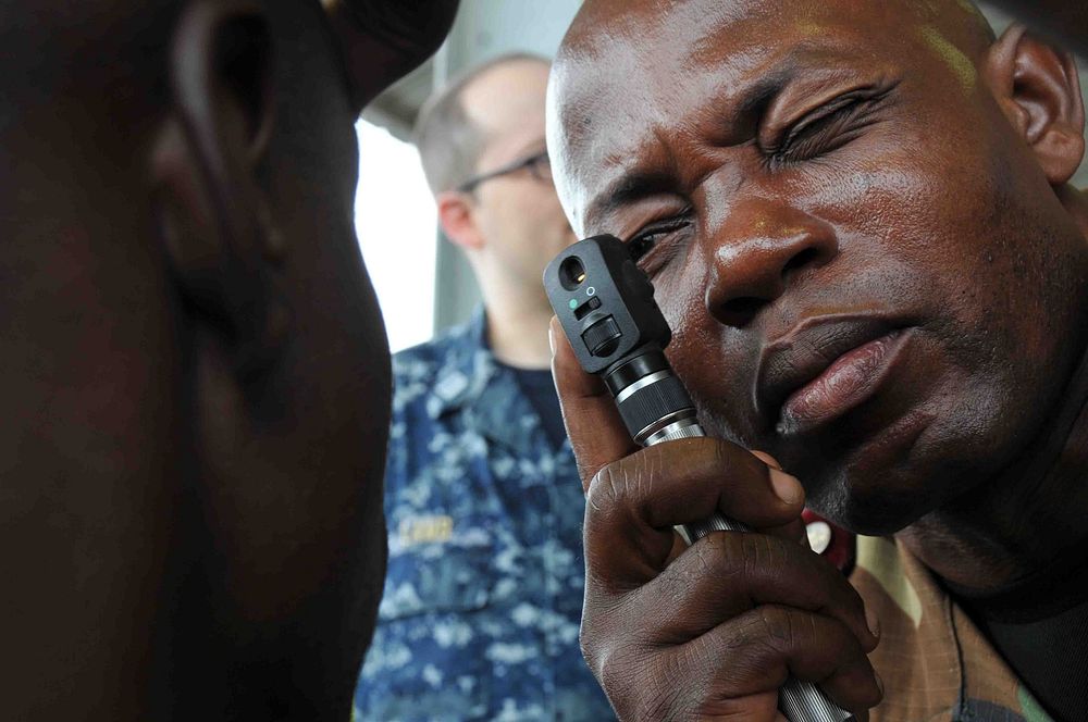 A member of the Cameroonian Rapid Intervention Battalion gives an eye exam with equipment provided by the U.S. Navy during a…