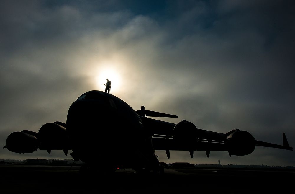 U.S. Air Force Tech. Sgt. Andrew Gravett, a crew chief with the 437th Aircraft Maintenance Squadron, walks along the top of…