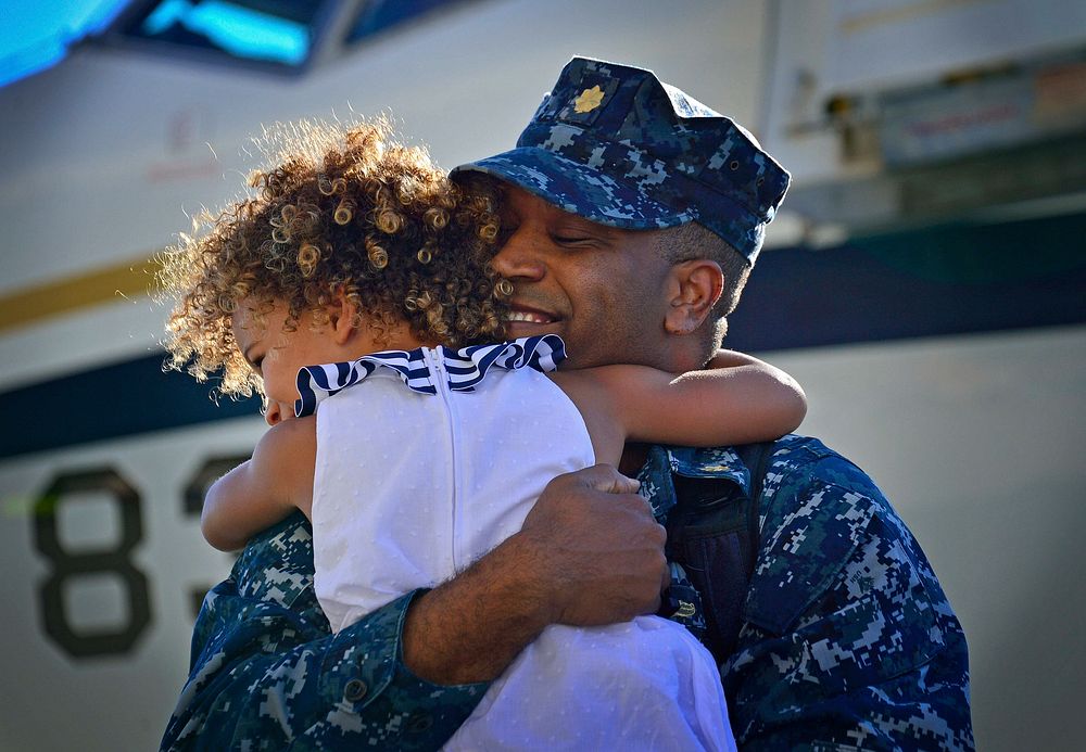 U.S. Navy Lt. Cmdr. Charles Harris, assigned to the USS Freedom (LCS 1), embraces his daughter during a homecoming…
