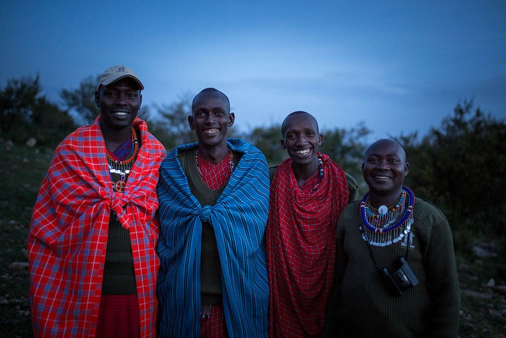 Maasai guides and trackers pose for a photograph after sunset in the Ol Kinyei Conservancy in Kenya's Maasai Mara